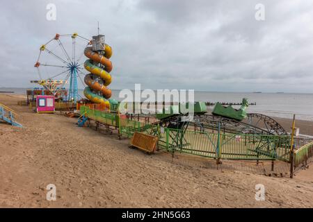 Closed funfair rides on the beach at Cleethorpes, Humber Estuary, North East Lincolnshire, UK. Stock Photo