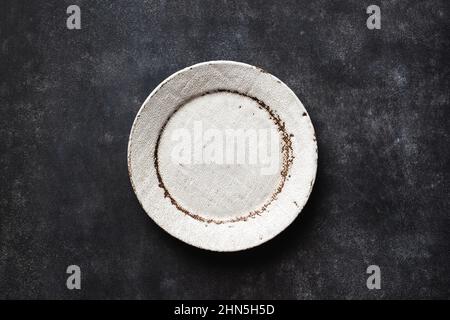 Empty Craft Ceramic Plate On Black Background. Top View Copy Space Stock Photo