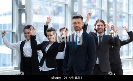 Cheering business people workers with raised arms in the office Stock Photo