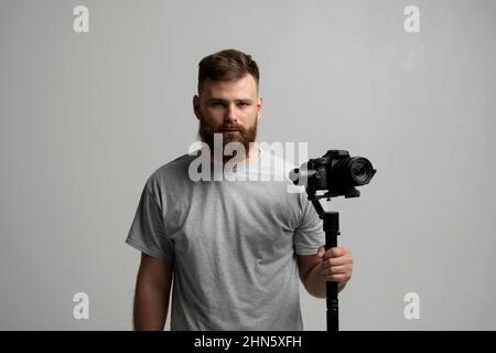 Professional videographer filmmaker cinematographer dop using dslr camera on gimbal stabilizer isolated on white background. Directop of photography Stock Photo