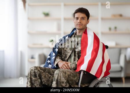 Handsome military guy in wheelchair with flag of the US Stock Photo
