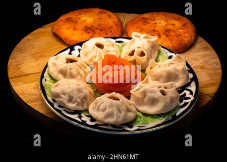 Manta rays with juicy meat on a plate on a wooden tray with baked pies Stock Photo