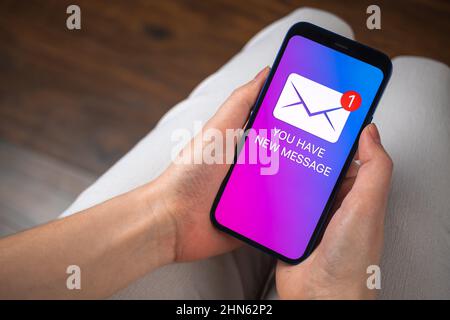 Hands holding smartphone with new message concept on screen. New e-mail notification business background Stock Photo