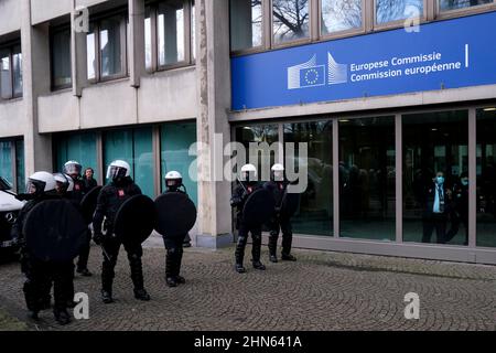 Brussels, Belgium. 14th Feb, 2022. Police officers in riot gear stand next to demonstrators during an unauthorised demonstration of Freedom Convoy against coronavirus disease (COVID-19) in Brussels, Belgium on February 14, 2022. Credit: ALEXANDROS MICHAILIDIS/Alamy Live News Stock Photo