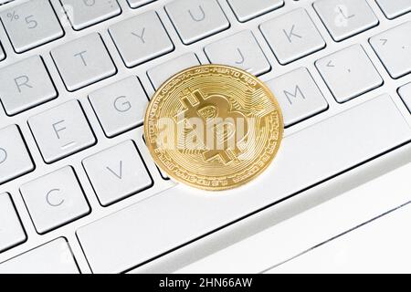 Bitcoin crypto currency. Gold bitcoin and computer keyboard. Golden digital cryptocurrency coin. Electronics finance money symbol. Bitcoin on laptop Stock Photo
