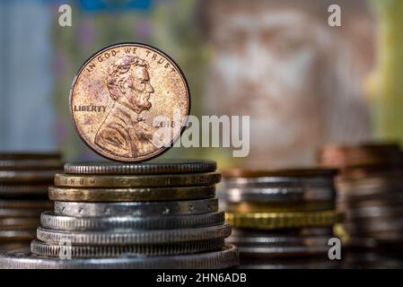 Inflation Interest Rates Penny on top of Pile of Coins Stock Photo