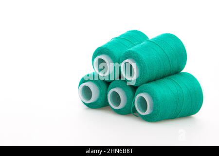 Green spool of thread isolated on white background. Skein of woolen threads. Yarn for knitting. Materials for sewing machine. Coil Stock Photo