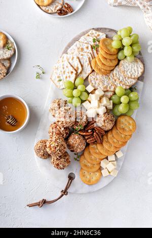 Cheese balls or truffles on a cheese board with crackers Stock Photo