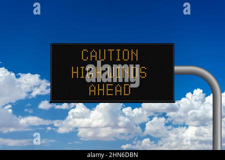 Caution High Winds Ahead variable highway sign with a cloudy sky Stock Photo