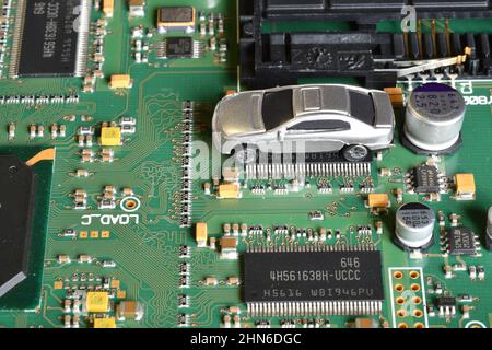Toy cars on electronic board and microchip. The shortage of microchips and semiconductors creates a shortage of new cars. Conceptual image for semicon Stock Photo