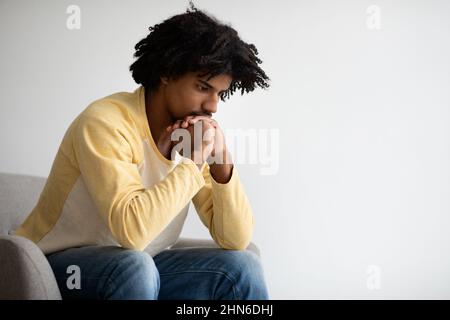 Contemplation Concept. Closeup Shot Of Thoughtful Young Black Man Sitting In Armchair Stock Photo