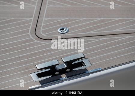 Close up view of front part of the boat at sunny day, bow of the boat, forepeak, hooks for a cable, the wooden deck, white color  Stock Photo