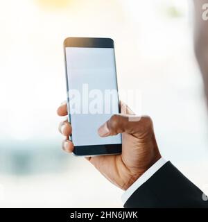 Staying close to all his connections. Closeup shot of an unrecognizable businessman using a cellphone in an office. Stock Photo