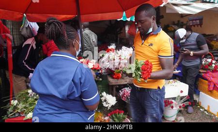 Nairobi, Kenya. 14th Feb, 2022. A vendor arranges flowers at a flower market on Valentine's Day in Nairobi, capital of Kenya, Feb. 14, 2022. The flower market is crowded with customers as well as deliverymen trying to get the delivery on time on Valentine's Day. Credit: Shi Yu/Xinhua/Alamy Live News Stock Photo