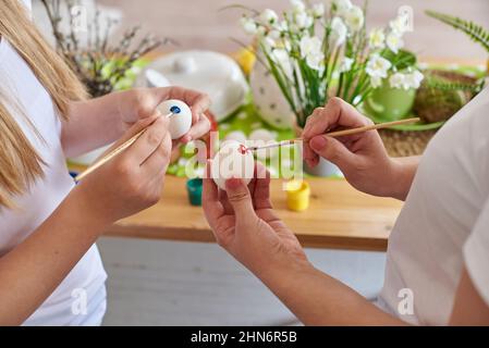 Hands coloring easter eggs close up. Stock Photo