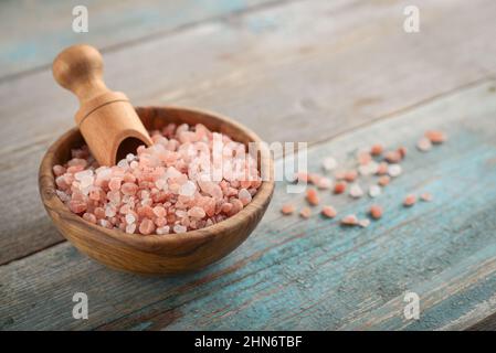 Himalayan pink salt in wooden bowl on wooden background Stock Photo