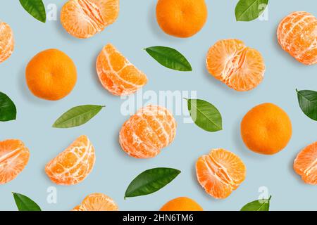 Seamless Pattern of whole  tangerines or mandarin orange fruits, peeled segments and leaves  on light blue background Stock Photo