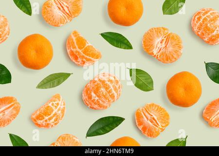 Seamless Pattern of whole  tangerines or mandarin orange fruits, peeled segments and leaves  on green background Stock Photo