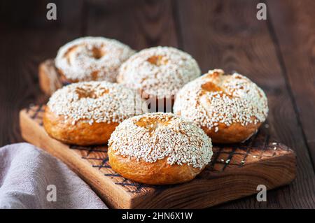 Freshly baked sesame seeded bagels on a wooden background. Stock Photo