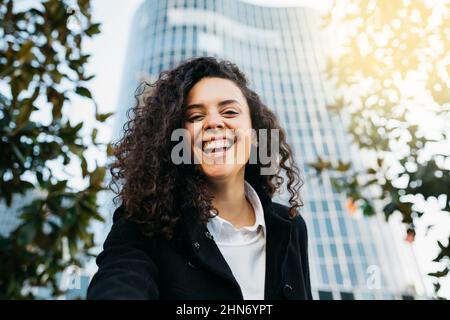 Portrait of a cheerful young latin american woman outdoors Stock Photo