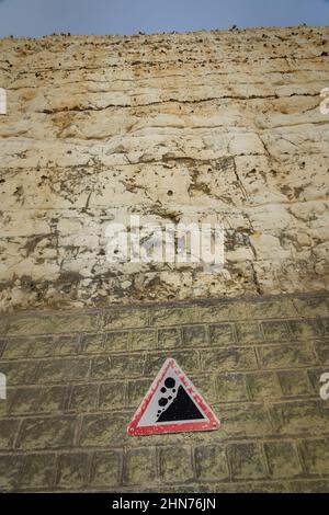 Warning of falling rocks on a chalk cliff face Stock Photo