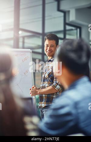 Presenting their top ideas. Shot of a young designer giving a presentation to his colleagues in an office. Stock Photo