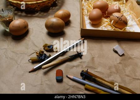 Tools for decorating Paschal eggs, Pysankas. Rustic background. Collection of eggs. Homemade pen for drawing eggs. Preparation holiday. Craft paper Stock Photo