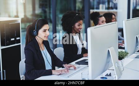 Were always busy solving problems. Cropped shot of a diverse group of businesswomen wearing headsets and using computers while sitting in the office Stock Photo