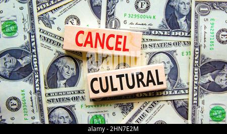 Cancel cultural symbol. Concept words Cancel cultural on wooden blocks on a beautiful background from dollar bills. Business and cancel cultural conce Stock Photo