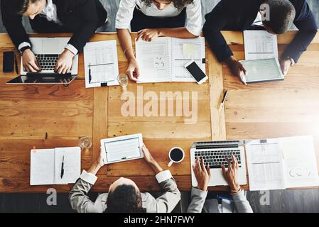 Getting down to some serious business. High angle shot of a group of businesspeople having a meeting in an office. Stock Photo