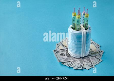 Insulin syringe pens wrapped in medical masks on dollar bills Stock Photo