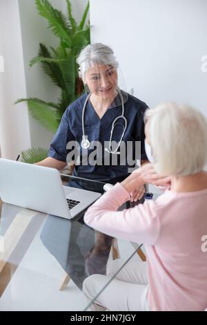 Medical specialist visiting elderly patient in her home Stock Photo