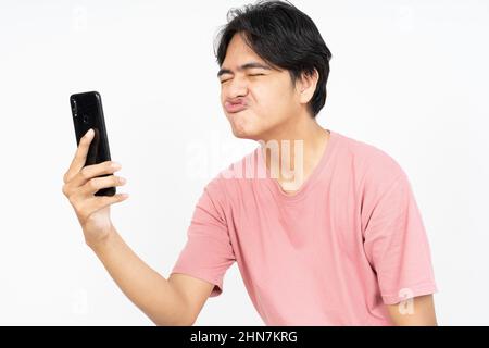 Asian man send love sign to girlfriend online in the smartphone application Stock Photo