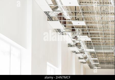 Modern Commercial Building Warehouse Construction Site. Finishing Ceiling Elements and Painting Walls. Stock Photo