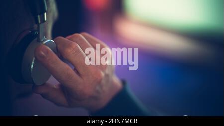 Caucasian Men Listening Music Using Wireless Headphones. Close Up Photo with aRight Side Copy Space. Sound Technologies Theme. Stock Photo