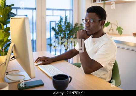 Thoughtful web developer work on computer, programmer trying to find solution for bug in app code Stock Photo