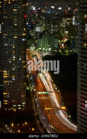 The night view of the wide Kaigan dori motorway among the skyscrapers of Shinbashi. Tokyo. Japan Stock Photo