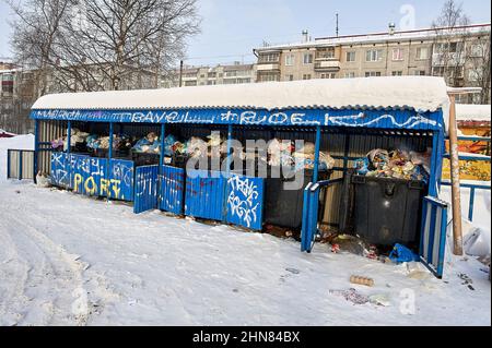 full garbage cans are on the garbage site in winter Stock Photo