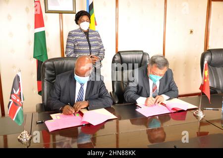 Nairobi, Kenya. 14th Feb, 2022. Officials of China and Kenya sign documents during the handover ceremony of the eighth and last batch of 2018 Chinese Food Aid Program in Nairobi, capital of Kenya, Feb. 14, 2022. Kenya on Monday held handover ceremony of the eighth and last batch of 2018 Chinese Food Aid Program to boost the war against hunger and malnutrition in Kenya that has escalated amid recurrent droughts. Credit: Charles Onyango/Xinhua/Alamy Live News Stock Photo