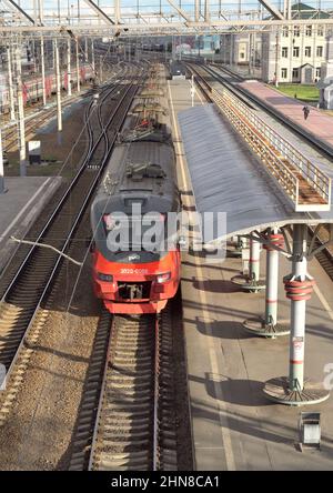 Novosibirsk, Siberia, Russia - 05.25.2020: The modern red train stands on the tracks at the passenger covered empty platform, the railway tracks to th Stock Photo