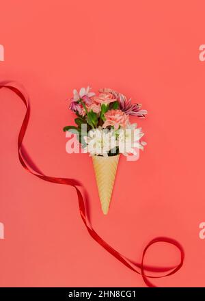 Creative spring layout made of flowers with copy space. Flat lay bouquet. Ice cream waffle cornet with pastel various flowers over pastel color backgr Stock Photo