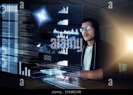 He can hack through any security measure. Shot of a young hacker cracking a computer code in the dark. Stock Photo