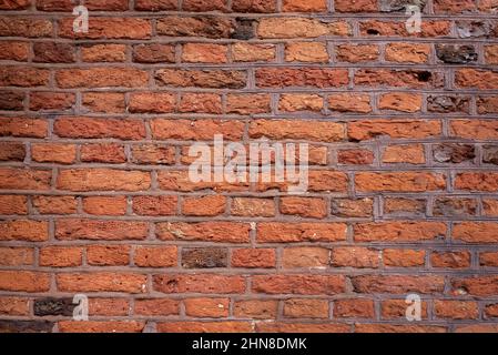 Old brick wall background, brick wall texture. Old broken brick, cement joints, closeup. crumbles with age. Stock Photo