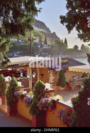 Hurzuf, Crimea, Russia-10.25.2019: Street cafe in the early morning in Gurzuf on the background of rocks. Tourist destination Stock Photo