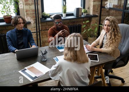 Group of young business people discussing and planning together at the table during meeting at board room Stock Photo