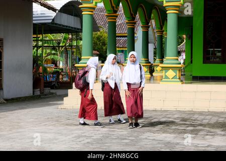 Lampung, Indonesia, December 17 2021- Defocused on Elementary school children go to school on foot with bags on their backs with their friends Stock Photo