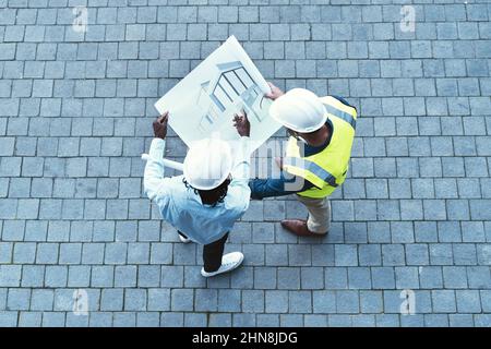 Sharing his ideas and vision. High angle shot of two engineers looking at a blueprint. Stock Photo