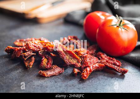 Sun dried tomatoes on a black table. Stock Photo