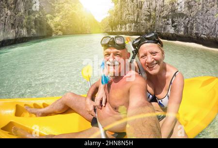 Senior happy couple taking selfie on kayak at Big Lagoon in El Nido Palawan - Travel to Philippines wonders - Active elderly concept around the world Stock Photo