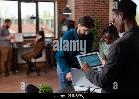 Multiracial executive managers analyzing company turnover working at marketing strategy discussing business collaboration in startup office. Diverse team brainstorming ideas for project Stock Photo